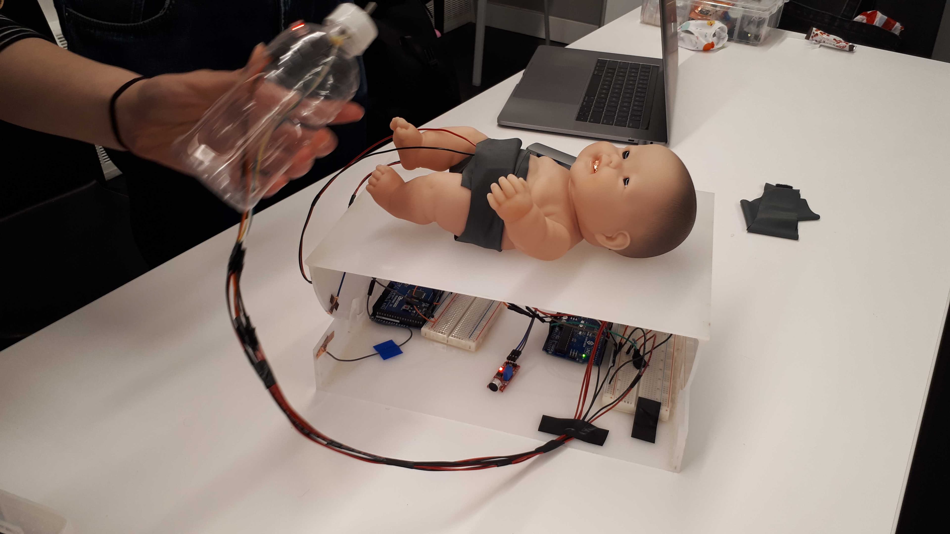 A baby crib outfitted with a doll and baby care equipment